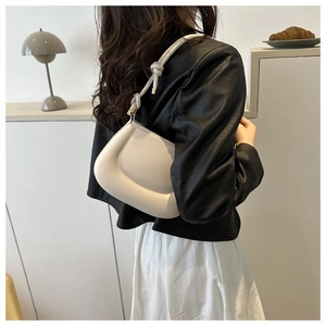 Détail du sac à bandoulière blanc crème avec sangle nouée et fermoir en métal poli