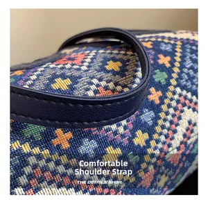 Detail of blue ethnic canvas tote with cross-stitch pattern and leather shoulder strap