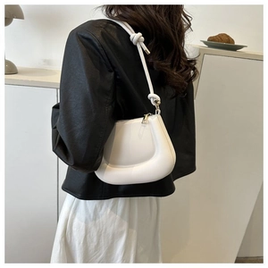 Détail d'un sac demi-lune rembourré blanc avec bandoulière à nœud élégant