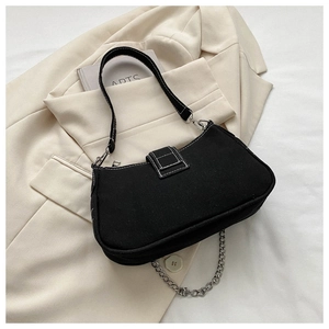 Detail view of black canvas underarm bag with white contrast stitching and silver chain