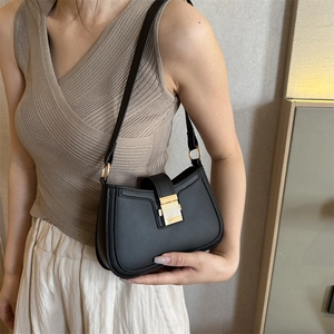 Minimalist black PU leather underarm bag with gold metal buckle and slender shoulder strap