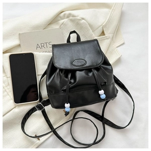 Detail eines schwarzen Lederrucksacks mit Fashion-Prägung und bunten Kordelperlen
