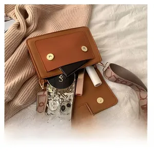 Brown crossbody bag internal capacity view showing phone and cosmetics inside