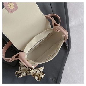 Detail view of pink crossbody bag interior featuring zipper pocket and magnetic buckle