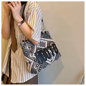 Close-up of bohemian woven tote bag with colorful geometric patterns and metal chain strap