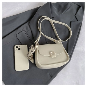 Detail of off-white semi-circle crossbody bag with decorative silk scarf and adjustable strap