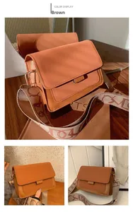 Close-up of brown crossbody bag with wide woven strap and jacquard pattern detail
