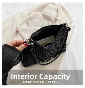 Détail de la capacité interne spacieuse et de la fermeture éclair du sac noir plissé