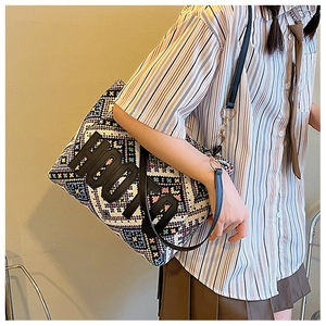 Detail of bohemian tote bag featuring colorful geometric embroidery and black HOON patch