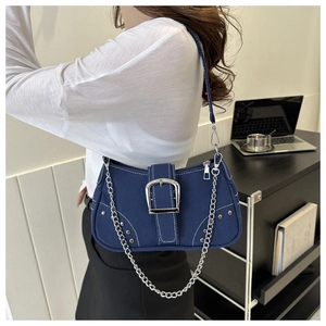 Detail of blue denim shoulder bag featuring silver buckle and decorative white stitching