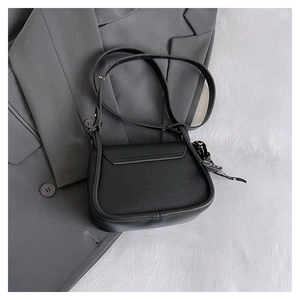 Chic black crossbody bag detail with elegant black and white printed scarf decoration