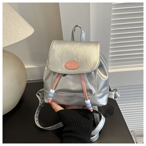 Detaillierte Nahaufnahme eines Mini-Rucksacks in Silber-Metallic mit rosa Fashion-Aufnäher