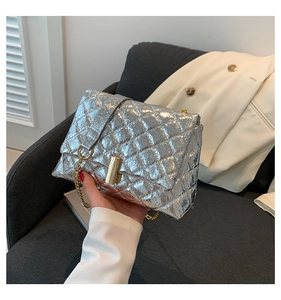 Close-up of a silver quilted handbag with golden twist lock and elegant chain strap