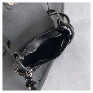 Macro view of interior zipper pocket and silk scarf detail on black crossbody bag