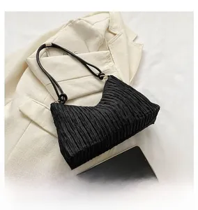 Détail du sac à bandoulière noir plissé montrant les plis verticaux et les doubles lanières
