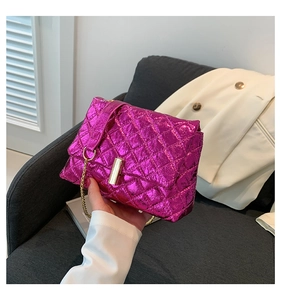 Close-up of metallic purple quilted handbag with gold chain strap and luxury lock