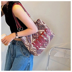 Detail of geometric woven tote bag with HOOTO leather logo and red shoulder straps
