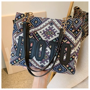 Detailed close-up of ethnic geometric woven tote bag with HOOTO patch and chain strap