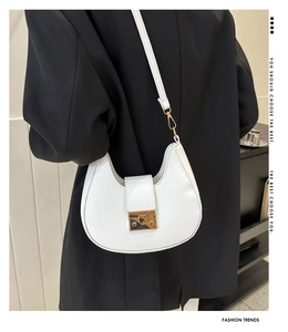 Detailed view of white half-moon saddle bag with gold buckle on a fashion model