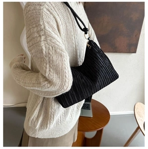 Vue détaillée d'un sac hobo plissé noir avec chaîne à anneaux métalliques et zip