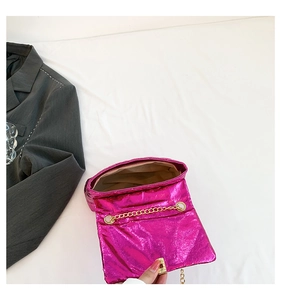 Macro view of metallic pink quilted handbag interior with gold chain strap detail