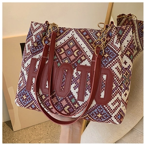 Detail of ethnic woven tote bag with geometric patterns and gold chain leather handle