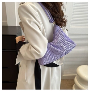 Détail du sac à main plissé lilas avec bandoulière à nœud porté par un mannequin