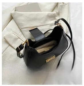 Interior capacity detail of black half-moon shoulder bag with wallet and phone inside