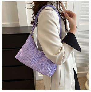 Détail du sac à bandoulière plissé violet clair avec une texture de tissu élégante