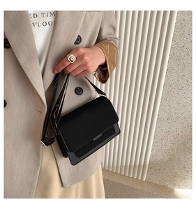 Detail of black frosted crossbody bag featuring a wide logo-print shoulder strap