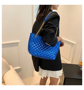 Détail du sac cabas matelassé bleu métallisé avec chaîne dorée sur modèle