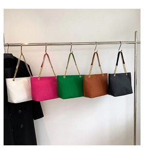 Detalle de bolsos tote en cinco colores con correas de cadena y texturas tejidas