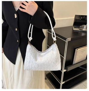 Détail du sac plissé blanc avec bandoulière en corde tressée et anneaux métalliques