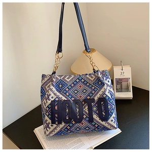Detail of woven ethnic tote bag with HOOTO embroidery and gold metal chain strap