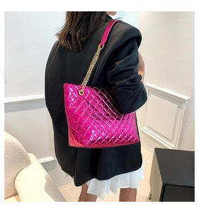 Détail macro du sac cabas matelassé magenta métallisé avec chaîne dorée et cuir