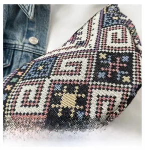 Detail showing the intricate bohemian woven pattern and colorful fabric texture of the bag