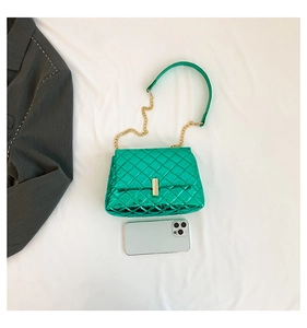 Metallic green quilted chain bag with gold buckle compared to smartphone size