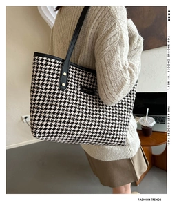 Detail view of large plaid tote bag with black PU straps and gold rivet accents