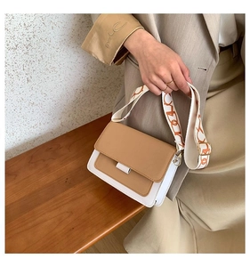 Detail of khaki flap and white crossbody bag with vintage jacquard wide shoulder strap