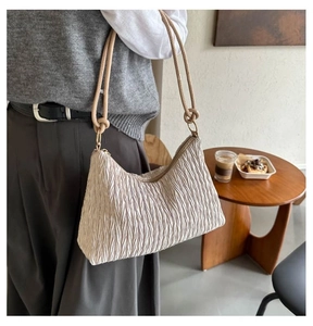 Détail du sac cabas plissé crème avec textures plissées délicates et fines anses nouées