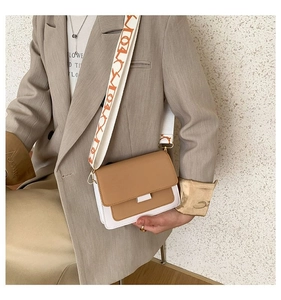 Detail of white and camel crossbody bag with a wide geometric patterned shoulder strap