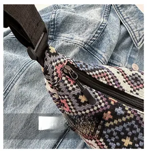 Detail view of the smooth zipper and ethnic woven fabric texture on the crossbody bag