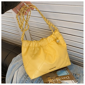 Detail of yellow quilted chain bag with gold chain strap and drawstring design