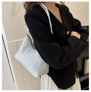 Vue détaillée du sac à bandoulière plissé argenté avec texture métal et sangle blanche