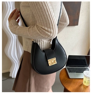 Detail of black crescent hobo bag featuring premium PU texture and gold metal buckle lock