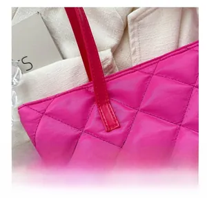 Dettaglio ravvicinato delle cuciture rinforzate sul manico della borsa trapuntata rosa