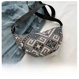 Close-up of geometric woven moon bag with ethnic pattern and adjustable nylon strap