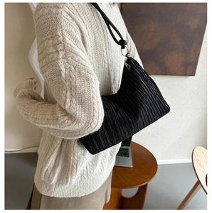 Détail du sac hobo noir plissé avec finitions élégantes en anneau métallique doré