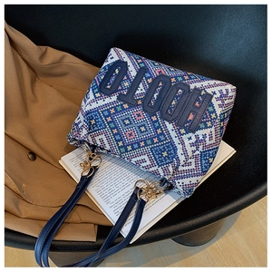 Macro shot of ethnic geometric woven texture with navy leather HOOTO logo patch