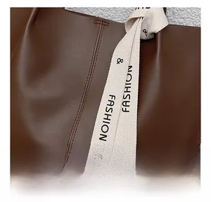 Detail of brown faux leather tote bag featuring a decorative fashion print silk scarf tie